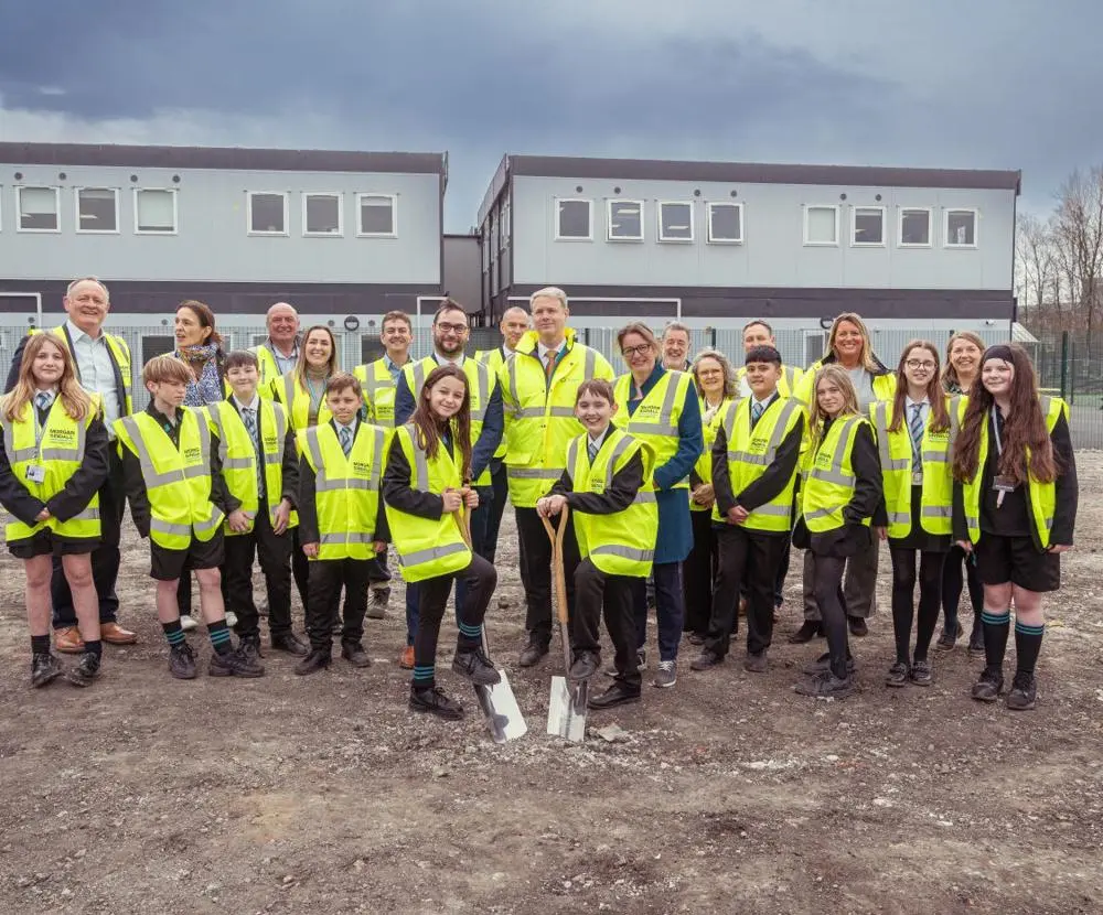 leader with a group of school children on a building site