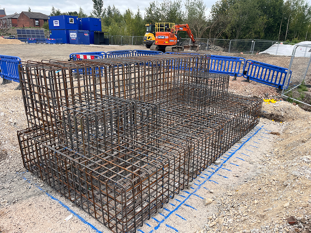 A number of steel cages stacked next to each other on a building site