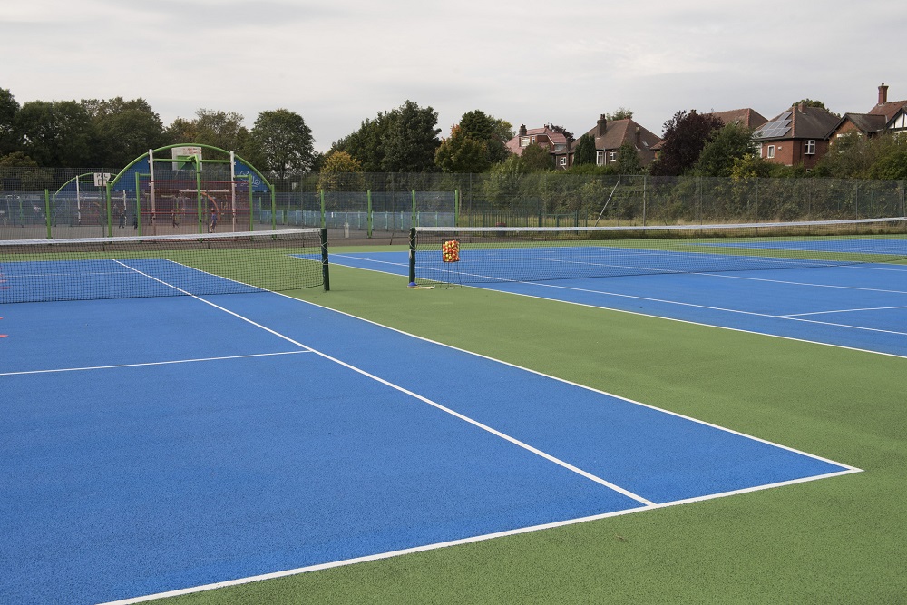Blue surfaced tennis courts and nets.