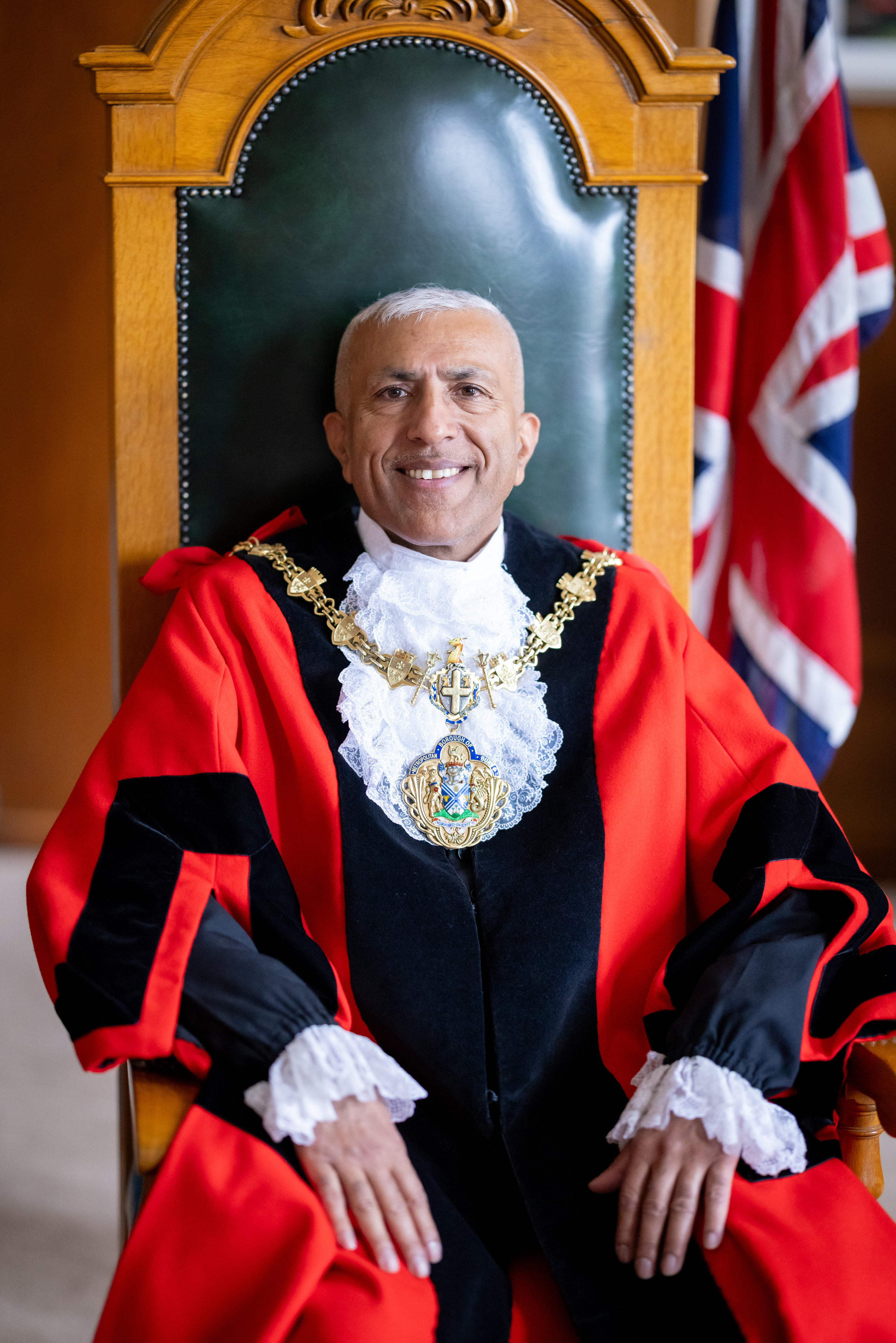 The Mayor, Councillor Mohammed Tahir Rafiq, sat in a chair wearing red ceremonial robes and the gold chain of office