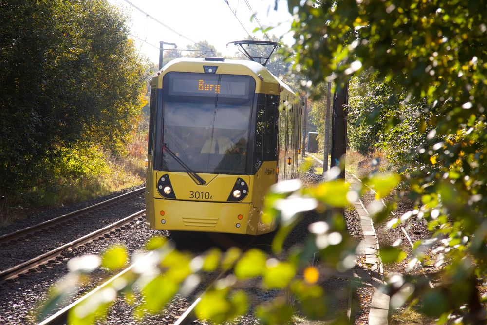 A yellow tram going to Bury.