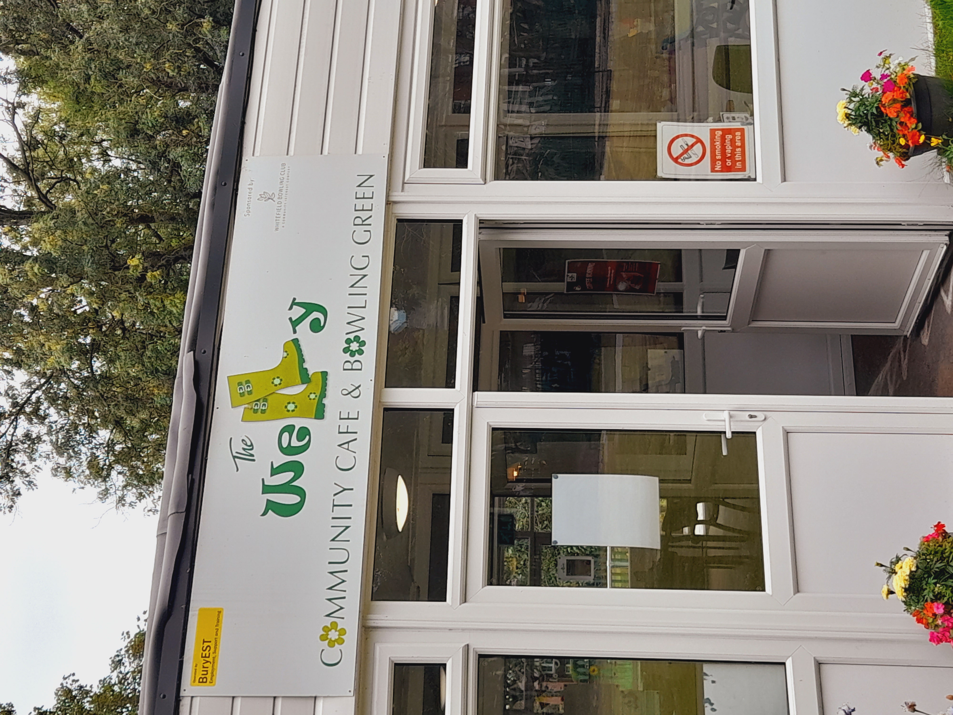 Door entrance to The Welly community cafe with a sign above the doorway.