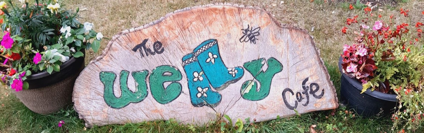 Welly cafe written on a cut tree round