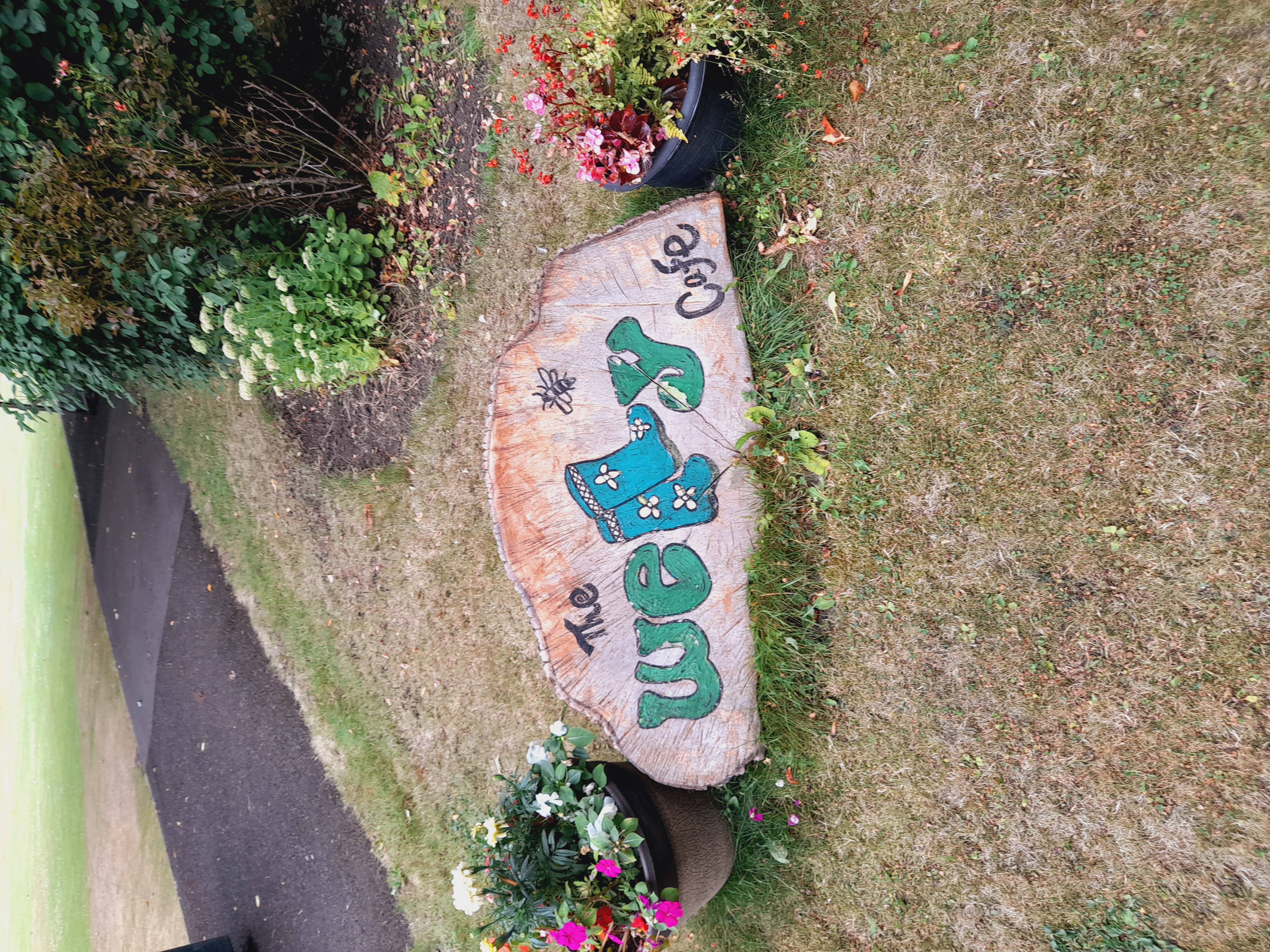 The Welly cafe sign painted on a slice of tree wood.