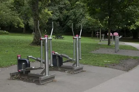 Metal gym equipment by a path,