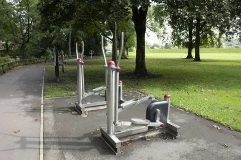 Metal gym equipment next to field.
