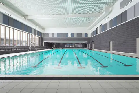 Large indoor 6-lane swimming pool with a wall of windows alongside the left side of the room